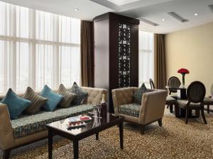 a living room with a couch and chairs and a table at Movenpick Hotel Qassim in Buraydah
