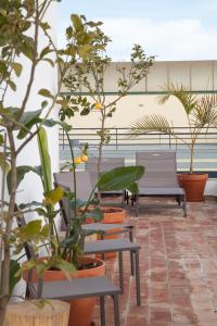 a patio with chairs and potted plants at Mar-Ria 8 in Fuzeta