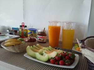 a table with a plate of fruit and two drinks at Tavira Monte in Tavira