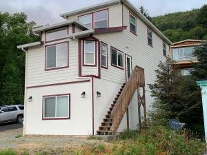 a large white house with a staircase in front of it at 3-bedroom house Rockaway Beach in Rockaway Beach