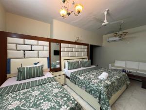 1 dormitorio con 2 camas y lavamanos en Hotel beachside, en Karachi