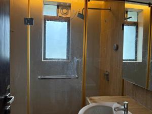 a bathroom with a sink and a shower with a window at BK's Villa Golf - By the 7th Hole in Ahmedabad