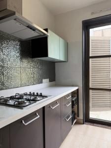 a kitchen with a stove and a counter top at BK's Villa Golf - By the 7th Hole in Ahmedabad +12 photos