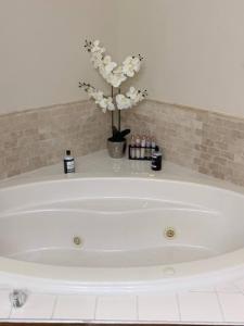 a white bath tub with a vase of flowers at Temple View Inn with Music Studio in Independence +91 photos