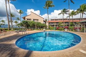 a large pool in front of a building with palm trees at Perch - Luana Kai Loft C308 in Kihei