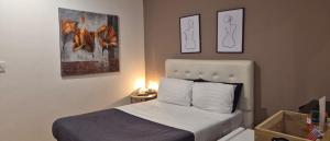 een slaapkamer met een bed en schilderijen aan de muur bij Hotel Zona G in Bogota