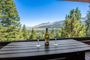 Eine Flasche Wein steht mit zwei Weingläsern auf einem Tisch. in der Unterkunft Bridges 107 in Mammoth Lakes