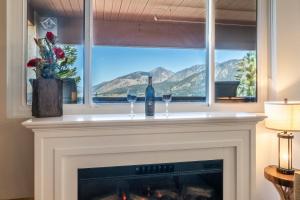 ein Kamin mit zwei Weingläsern und einem Fenster in der Unterkunft Bridges 107 in Mammoth Lakes