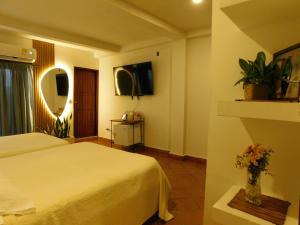 a hotel room with a bed and a vase of flowers at La casa del Colibri in Mompos