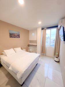 a bedroom with a white bed and a large window at Habitación con terraza in Puerto Ayora