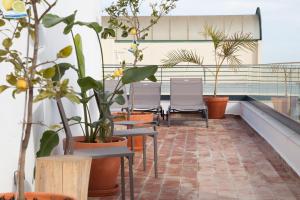 a row of chairs and potted plants on a balcony at Mar-Ria 4 in Fuzeta