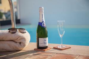 a bottle of champagne and a glass on a table at Mar-Ria 4 in Fuzeta