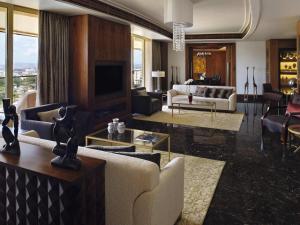 a living room with couches and a television at Mövenpick Ambassador Hotel Accra in Accra