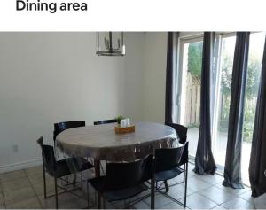 zona de comedor con mesa, sillas y ventana en Mariam House, en Chatham
