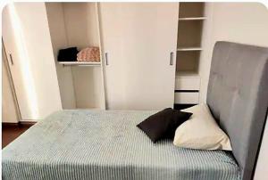 Un dormitorio pequeño con una cama con dos almohadas encima. en Fantastico, con balcones y bellas vistas, en Sucre 21 fotos más