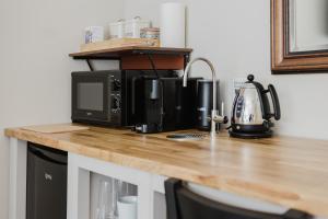 a counter top with a coffee maker and a microwave at Grace's Guesthouse Room 5 in Tring
