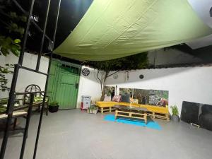 ティラナにあるBunkHomeの黄色のテーブルとベンチ、緑のドアのあるパティオ