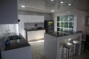 a kitchen with white cabinets and a counter with stools at Penthouses La Fe in Cartagena de Indias