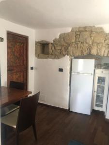 a kitchen with a white refrigerator and a stone wall at Ca' Parodi Bel View in Parodi Ligure
