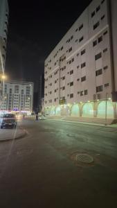 an empty parking lot in a city at night at التطوير الحضري فندق عقيق شارع ابراهيم الخليل in Al Masfalah