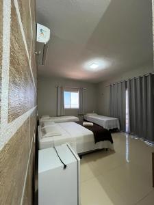 a hotel room with two beds and a window at Pousada e Restaurante Altas Horas Beach in Itapipoca +120 photos