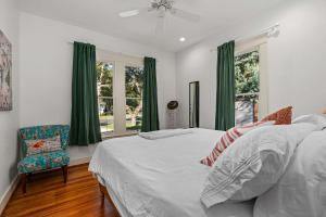 Un dormitorio con una cama y una silla y ventanas. en Bauern Haus - Game Room Fire Pit & More, en Fredericksburg 65 fotos más