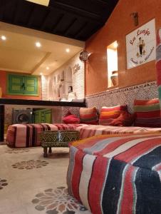 Una habitación con tres camas con almohadas de colores. en Riad Yousra, en Marrakech