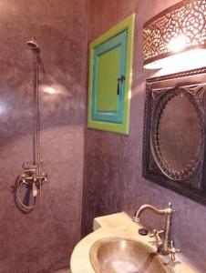 un baño con lavabo y espejo en Riad Yousra, en Marrakech