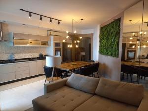 a living room and kitchen with a couch and a table at O maior condomínio residencial da Praia Grande de Ubatuba in Ubatuba