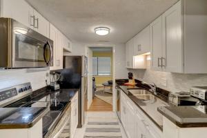 Una cocina con gabinetes blancos y electrodomésticos de acero inoxidable. en Family 2BR Retreat Near Beach Pool – Hilton Head, en Hilton Head Island
