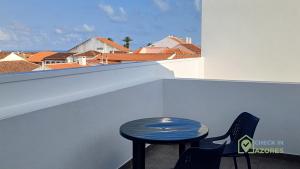 a table and two chairs on a balcony with a view at Terraço e vista deslumbrante no centro de Angra in Angra do Heroísmo