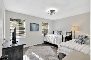 une chambre avec un lit, une télévision et un canapé dans l'établissement Central Hilton Head Retreat 2BR Near Beaches, à Île de Hilton-Head