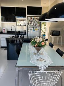 a kitchen with a table with a vase of flowers on it at MarisC&LHouse2-Quarto para casal in Bombinhas +20 photos