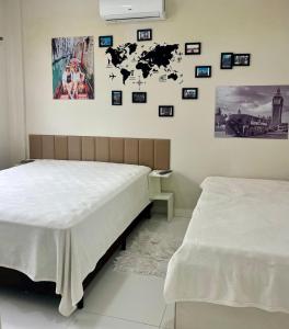 two beds in a room with pictures on the wall at MarisC&LHouse2-Quarto para casal in Bombinhas +19 photos
