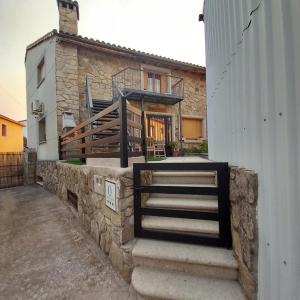 ein Haus mit einer Treppe, die zu einem Gebäude führt in der Unterkunft Aires Del Ambroz in Casas del Monte