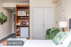 Postel nebo postele na pokoji v ubytování Queen Street City View Studio with AC, Pool and Gym + 12 fotografií