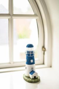 a model lighthouse sitting in front of a window at Denmark NN Scandinavian Villa Escape by the Sea in Solrød Strand
