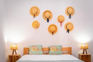 a bedroom with straw hats on the wall at Casa do Outeiro in São Bartolomeu do Outeiro