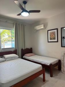 a bedroom with two beds and a ceiling fan at Casa da Felicidade em Araruama in Araruama +33 photos