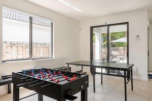 two ping pong tables in a room with windows at FL1 House NEW Miami Oasis Game Room & Firepit in Tamiami +58 photos