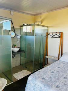 a bedroom with a glass shower and a sink at Chales Estrela Veadeiros Com Ofurô in Alto Paraíso de Goiás +24 photos