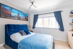 a blue bed in a bedroom with a large window at Detached Modern 3 Bedroom House in Wincanton