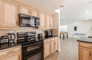 a kitchen with wooden cabinets and a stove top oven at CA3 House Spacious SoCal Home for Groups in La Palma