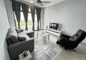 Una sala de estar con un sofá y sillas y un televisor. en Tamara Presint 8 Putrajaya Lakeview Suites, en Putrajaya