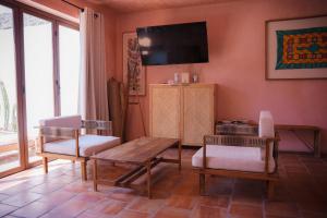 Una sala de estar con una mesa y sillas y un televisor. en Villa Santa María - Alberca Privada - Punta Pérula, en Pérula