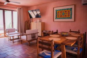 Un comedor con mesa y sillas de madera. en Villa Santa María - Alberca Privada - Punta Pérula, en Pérula