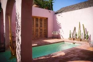 una piscina frente a una casa con cactus en Villa Santa María - Alberca Privada - Punta Pérula, en Pérula