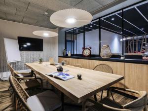 Una sala de conferencias con una gran mesa y sillas de madera. en ibis Styles Le Treport Mers Les Bains, en Mers-les-Bains
