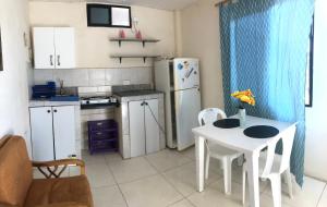 a kitchen with a white table and a white refrigerator at Hospedaje Maluli suit 4 in Santa Elena