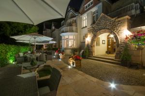 an outdoor patio with tables and umbrellas at night at Chateau La Chaire in Rozel